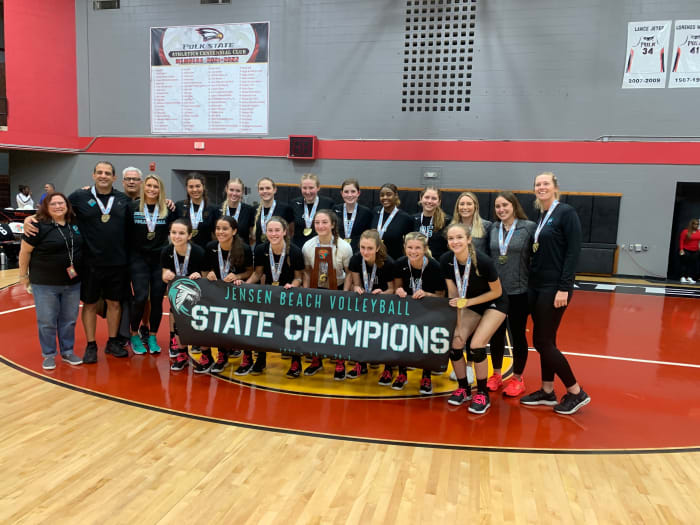 Jensen Beach stands with the state-championship trophy and a banner to match after the Falcons' 25-17 25-15 25-22 victory over Naples Barron Collier in the FHSAA Class 5A volleyball final.
